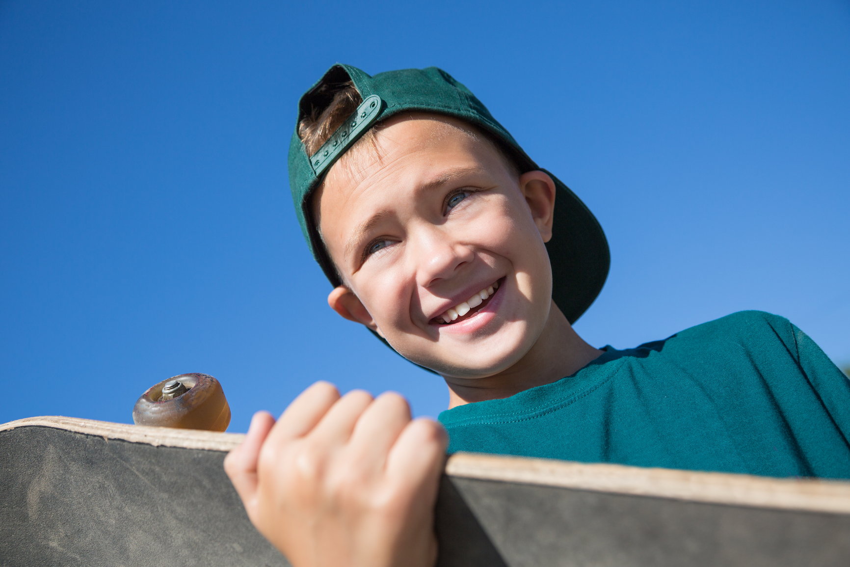 Portrait boy holding a skateboard.