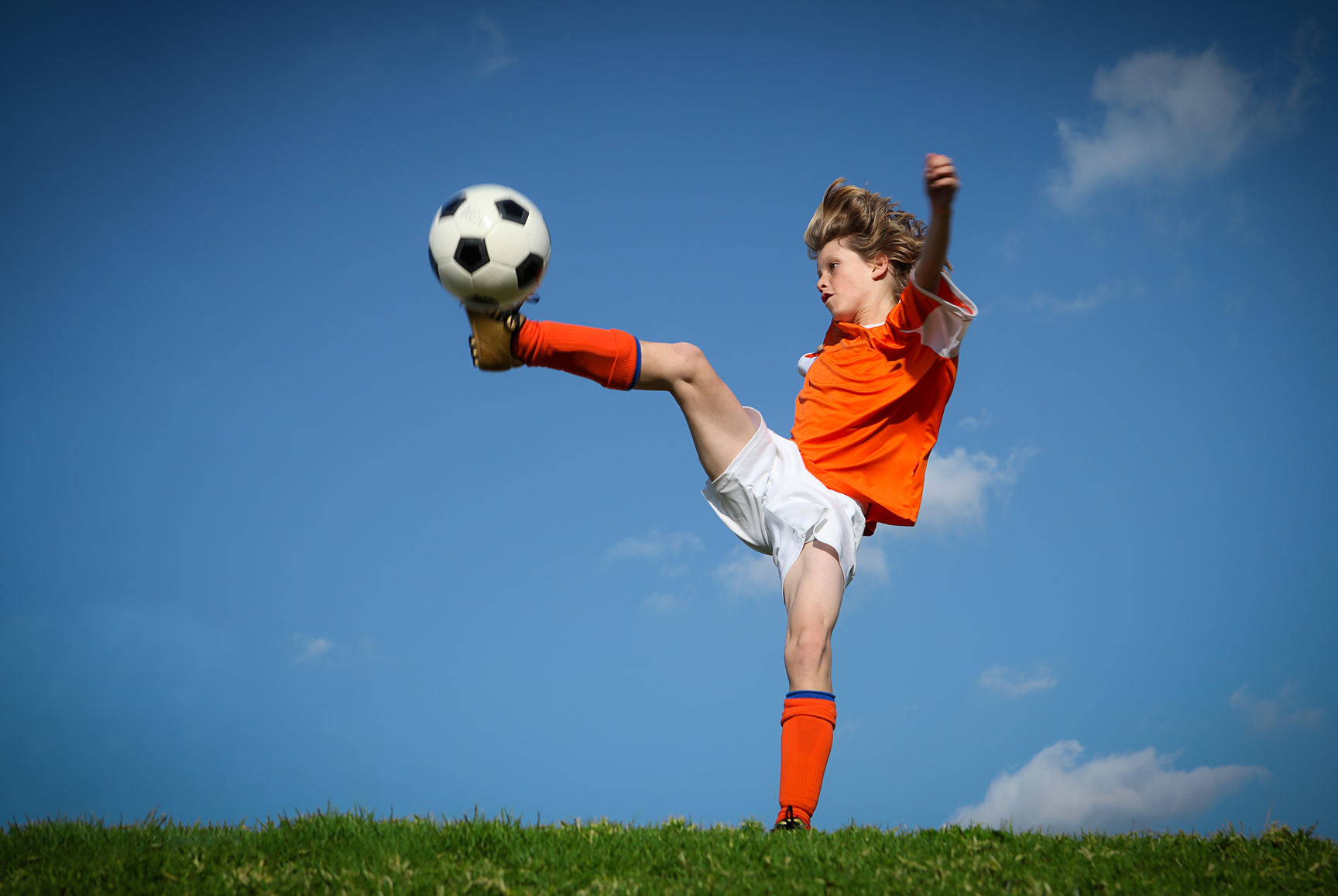 Child kicking playing football