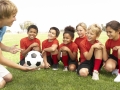 Young Boys And Girls In Football Team  With Coach